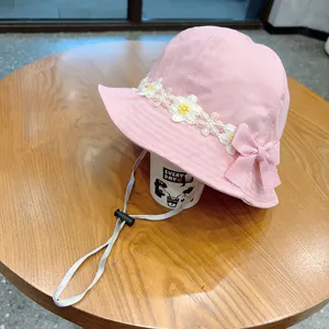 Pink toddler bucket hat with floral embroidery, sweet bow detail, and adjustable chin strap.