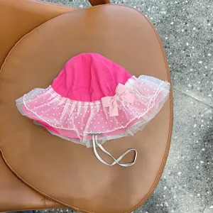 Detail shot of the cute pink baby bucket hat with white polka dot mesh ruffle and bow.
