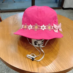 Pink children bucket hat with cute floral lace embroidery and bow, adjustable chin strap, detail.