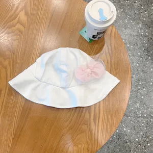 Infant white bucket hat detail shot, featuring a cute pink mesh bow for baby girls.