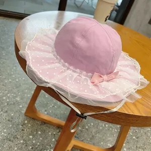 Pink baby sun hat detail showcasing cute white polka dot lace brim and adjustable chin strap.