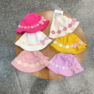 Detailed view of colorful baby bucket hats with floral lace trim and cute side bow ties.