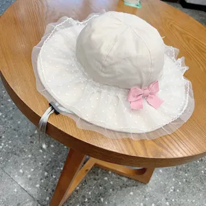 Detailed view of cute baby sun hat with lace mesh brim, pink bow and adjustable chin strap.