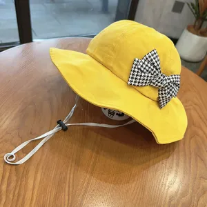 Kids yellow bucket hat with houndstooth bow and adjustable strap, cute sun protection hat.