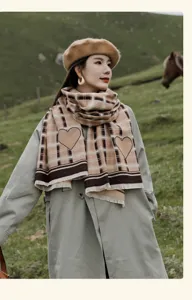 Outdoor detail shot of a stylish plaid scarf with heart pattern worn in a natural meadow.