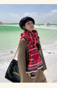 Detailed view of fashionable red plaid scarf showcasing chic winter pattern and heart motif.