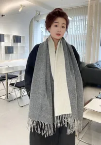 Gros plan sur l'écharpe bicolore à franges pour femme dans un style hivernal chaleureux.
