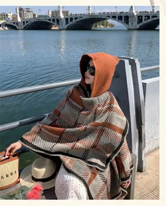 Outdoor lifestyle detail shot of a women's ethnic plaid hooded cape shawl, thick warm fabric.