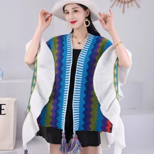 Vue détaillée du poncho en tricot ethnique avec vagues géométriques, manches blanches et franges.