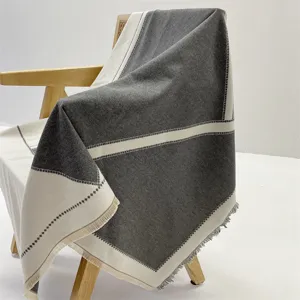 Detailed view of dual-color cashmere-feel blanket shawl draped gracefully on chair, soft texture.