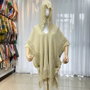 Beige knitted hooded poncho shawl for women, stylish fringe tassel winter warm outerwear.