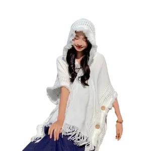 White knitted hooded poncho for women, stylish tassel cape sweater for travel and daily wear.