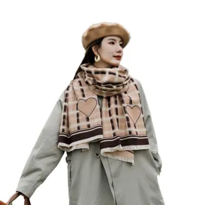 Stylish plaid scarf with heart pattern and chic beret worn by model, ideal for autumn.