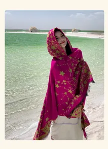 Vista dettagliata del poncho con cappuccio rosa vivace con motivo a stelle, ideale per viaggi.
