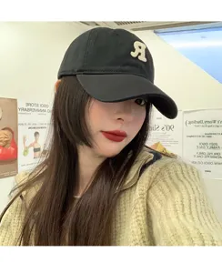 Detailed view of stylish black baseball cap with letter embroidery, Korean fashion design.