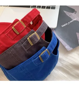 Detail shot of stylish cotton baseball caps in vibrant colors with metal buckle accents.