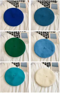 Detailed view of colorful wool berets in various vibrant shades, retro winter painter hats.