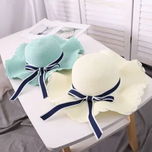 Wide brim straw hat with navy bow for women summer beach sun protection travel folding.