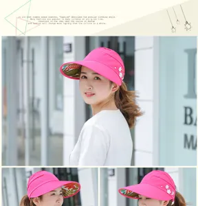 Detail view of women's pink sun visor hat featuring floral brim lining and elegant side pearls.