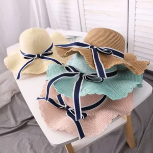 Detailed view of fashionable wide-brimmed straw hats with cute bow knots for summer beach.