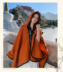 Detailed view of women's autumn winter orange hooded cloak with black trim and front button closure.
