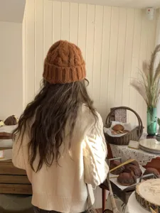 Caramel brown cable knit beanie hat detail view, soft autumn winter warm slouchy wool headwear.