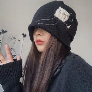 Black knitted beanie hat for women, vintage style with artistic face embroidery design.