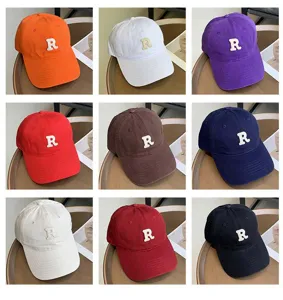 Gorra de béisbol multicolor con letra R bordada, visera curva estilo retro casual.