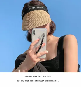 Straw sun visor hat detail showcasing the embroidered black brim band and stylish summer design.