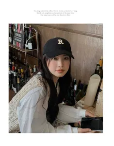 Vista detallada de la gorra de béisbol negra vintage con bordado de logo R y visera.