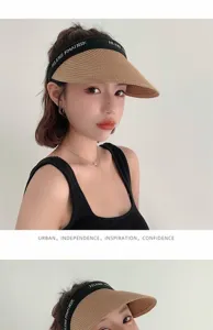 Stylish women's straw sun visor hat, empty top beach cap with black band for summer UV protection.