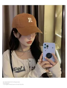 Gorra de béisbol marrón clásica con parche de letra R blanca, visera curva vintage.