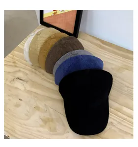 Detailed close-up showing stacked multi-color corduroy baseball caps with soft textured fabric.