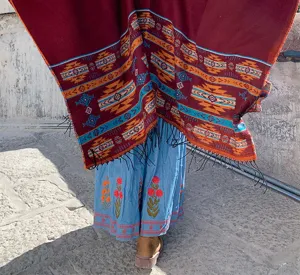 Outdoor detail shot of a boho ethnic style fringe shawl with geometric patterns worn outdoors.