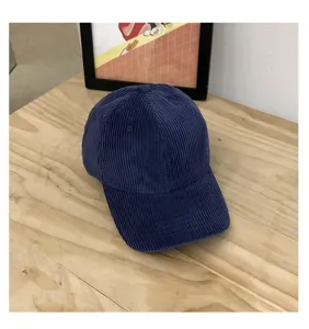 Detail view of the navy blue corduroy baseball cap, showcasing soft fabric and fine texture.