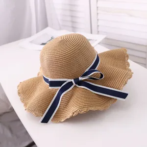 Detailed view of the summer straw sun hat with navy blue bow for women beach vacation.