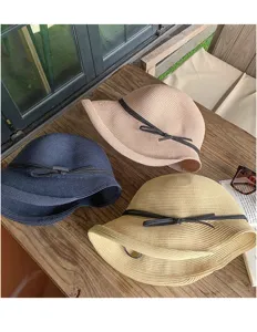 Detailed view of summer straw hats featuring a chic ribbon bow and wide brim design.