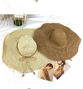 Handgemachte Damen Strohsonnenhut mit breiter Krempe und Perlenbändern für Sommerstrandurlaub.