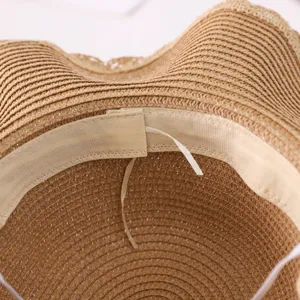 Detail view of the inner structure of a summer straw sun hat, showing woven texture.