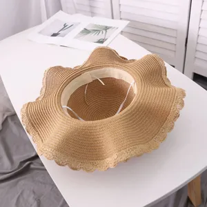 Detailed shot of a women's wavy brim straw sun hat, perfect for summer beach travel.