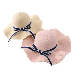 Wide brim straw hat for women summer beach sun protection with elegant navy blue bow.