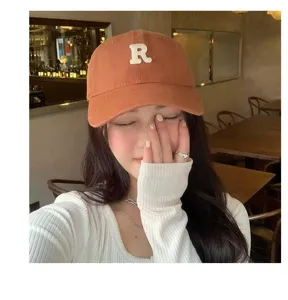 Gorra de béisbol naranja retro para mujer, diseño de ala curvada con letra R blanca.