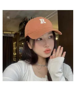 Gorra de béisbol anaranjada con bordado de letra R blanca y visera estilo retro.