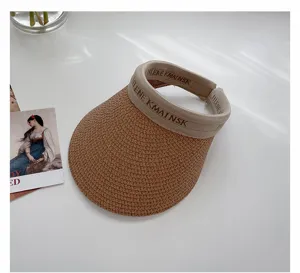 Close-up detail shot of woven straw sun visor hat, featuring stylish brim and clean texture.