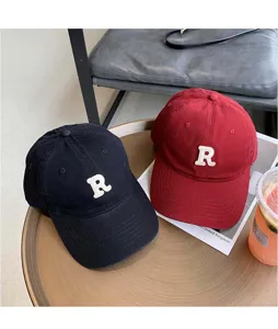 Vista detallada de la gorra de béisbol vintage negra y roja con bordado R, muy elegante.