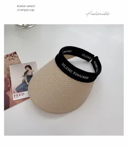 Detail shot of beige straw sun visor empty cap with black strap for women summer beach.