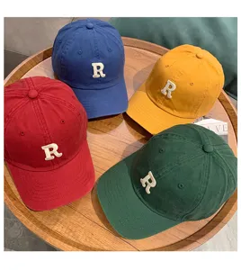 Detailed shot of retro washed cotton baseball caps with embroidered R letter in multiple vibrant colors.