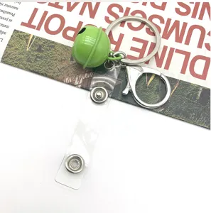 Close up detail of green bell keychain with metal lobster clasp and clear snap fastener strap.