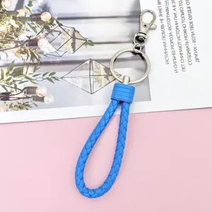 Detailed close-up of the vibrant blue braided leather keychain with sturdy metal ring.