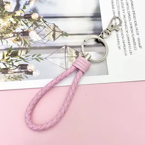 Pink braided leather wristlet keychain featuring silver metal hardware and a secure lobster clasp.